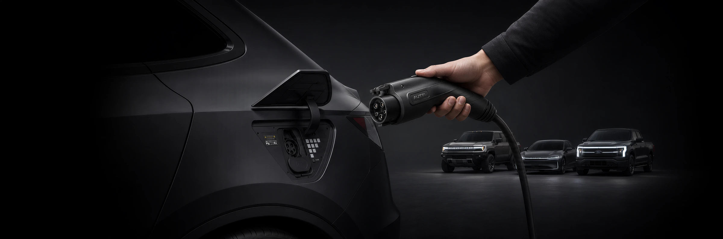 A hand holding a J1772 connector beside a vehicle charging port