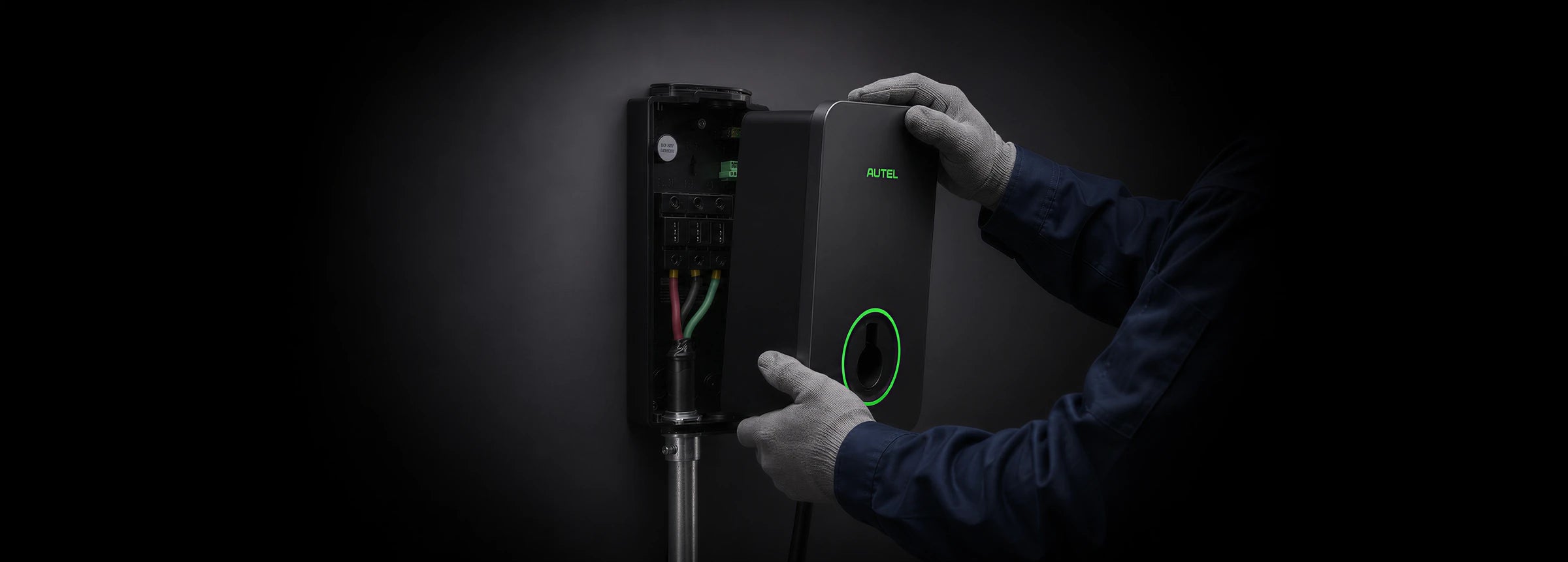 An installer's hands positioning the charger housing beside the wall-mounted backplate and wiring